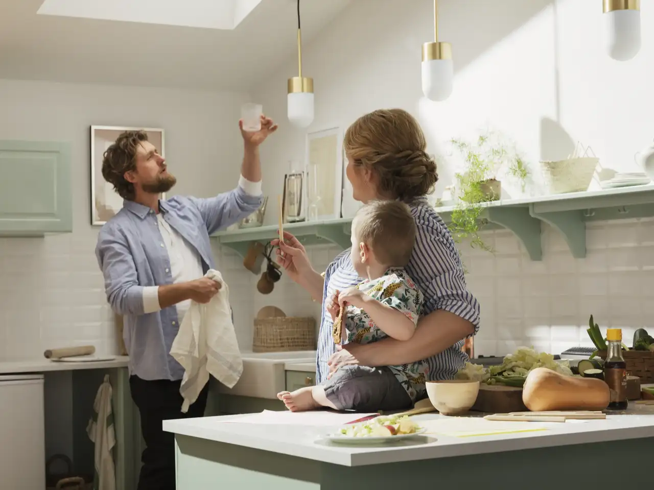 Famille avec enfant dans une cuisine équipée avec fenêtre de toit VELUX 