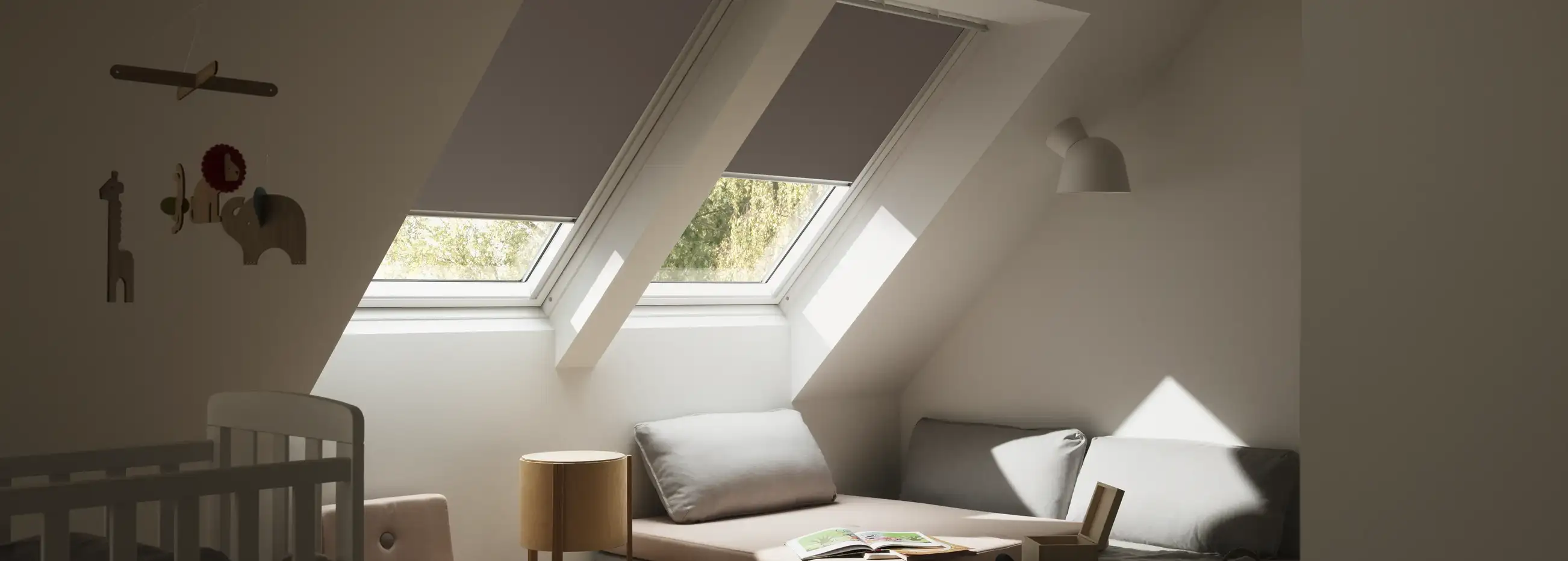 Attic kids room with sloped ceiling and VELUX roof windows, cozy decor.