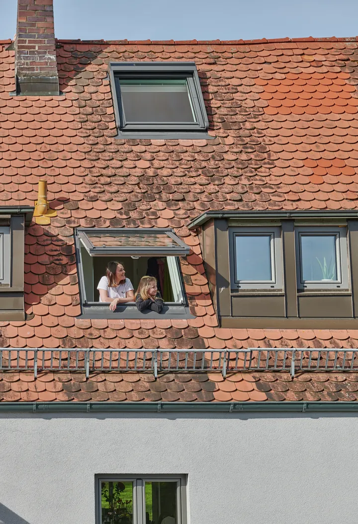 VELUX Dachflächenfenster auf Terrakottafliesen in einem ausgebauten Dachboden.