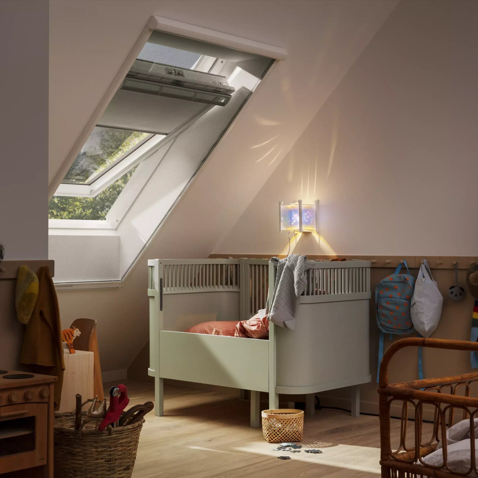 Attic kids room with sloped ceiling and VELUX roof window, cozy decor.