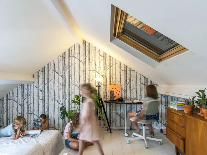 Kinder-Dachboden-Spielzimmer mit VELUX-Fenster, Birken-Tapete und Schreibtisch.