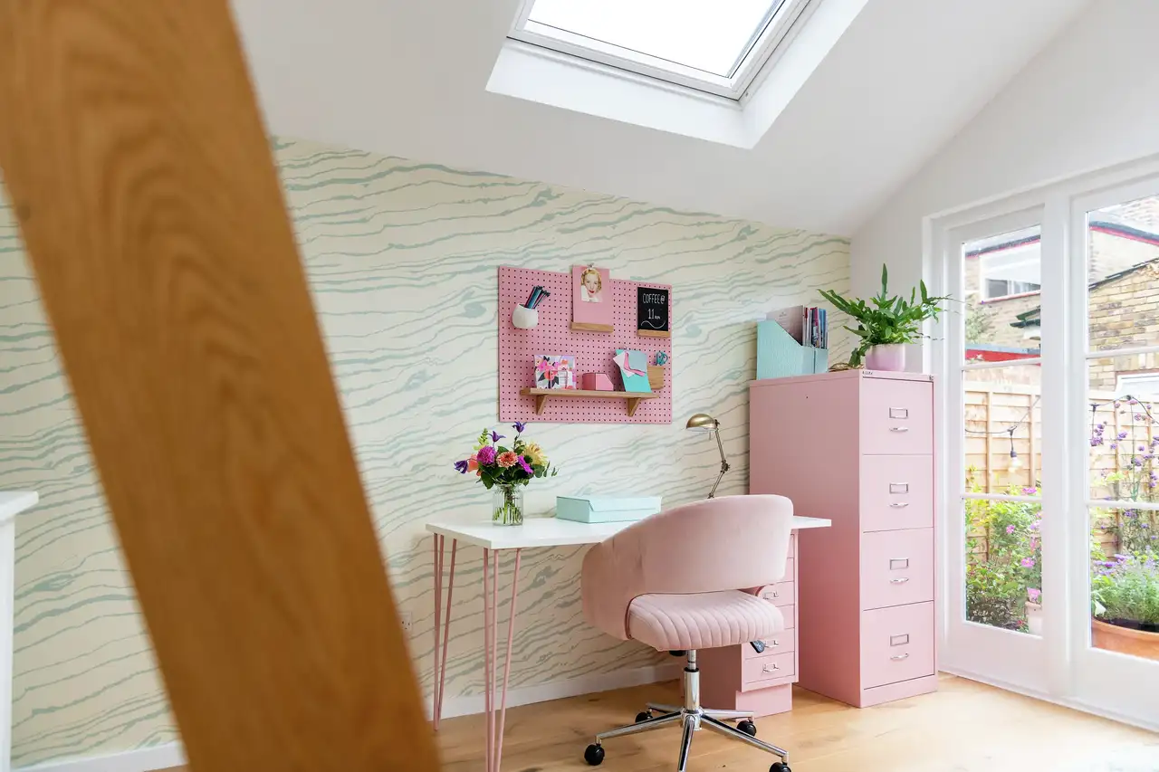 Bureau à domicile avec mobilier rose, mur vert clair aux nuances profondes et bureau placé sous une fenêtre de toit VELUX 