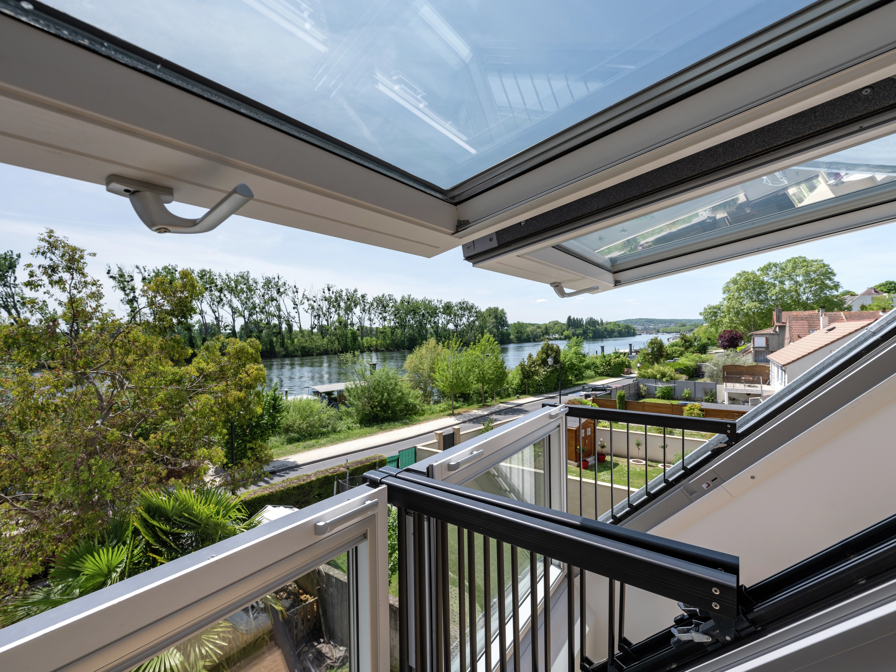 Vistas de la naturaleza con un río desde una vivienda con ventana de balcón VELUX.