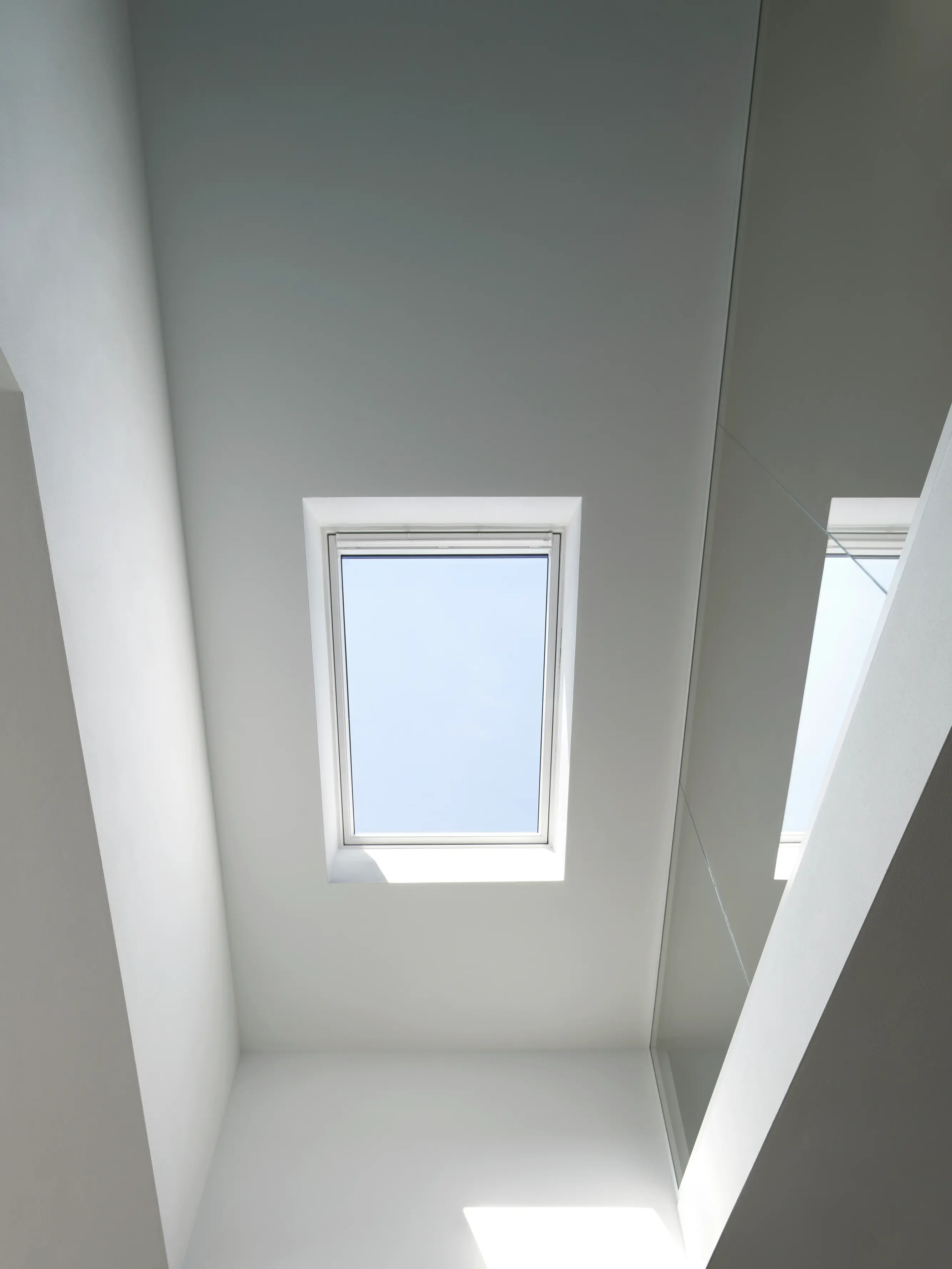 Stanza minimalista con luce naturale proveniente da una finestra per tetti VELUX.