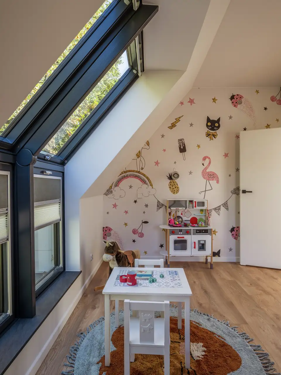 Chambre d’enfant mansardée avec papier peint coloré et motifs animaliers