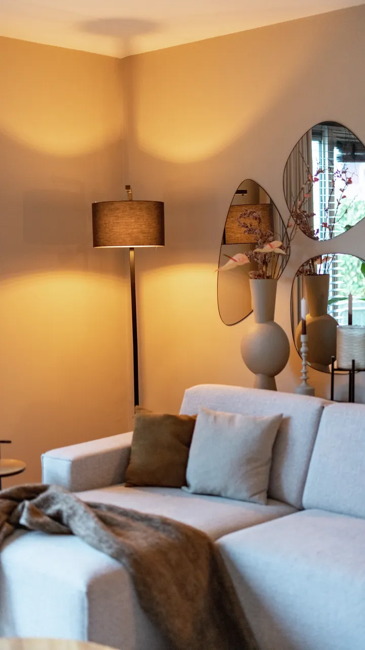 Ugodan dnevni boravak s mekim ambijentalnim svjetlom podne lampe i ogledalima koja reflektiraju toplinu. | VELUX