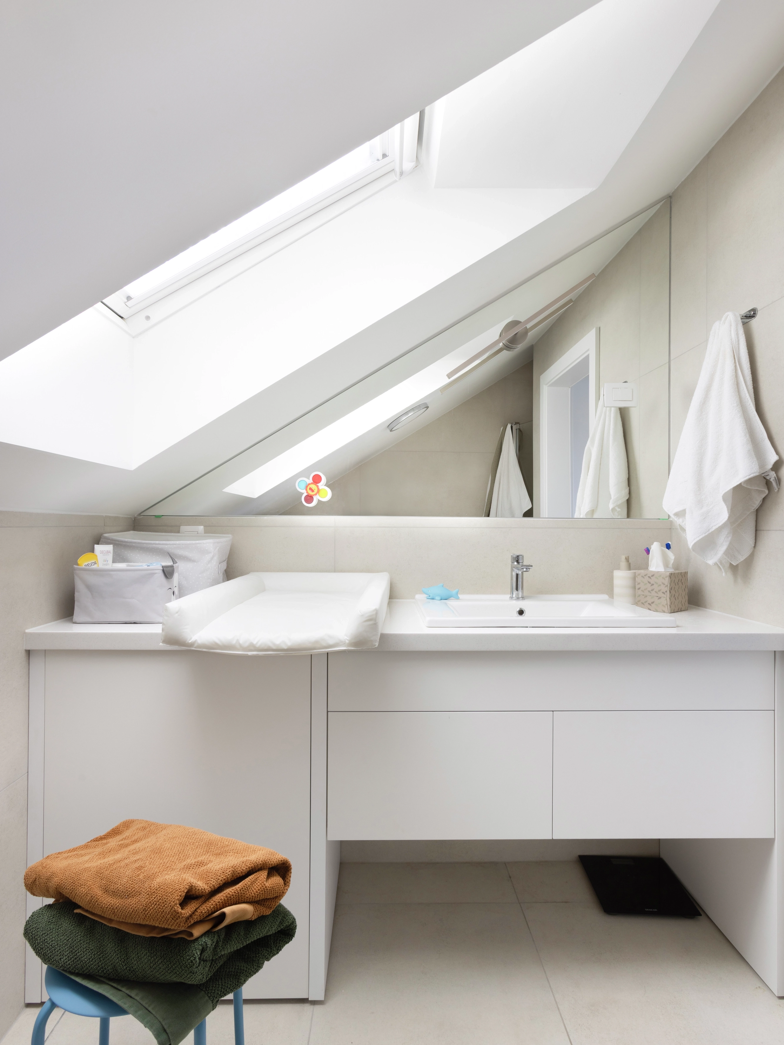Bathroom with sloped ceiling and VELUX roof window, bright and modern.