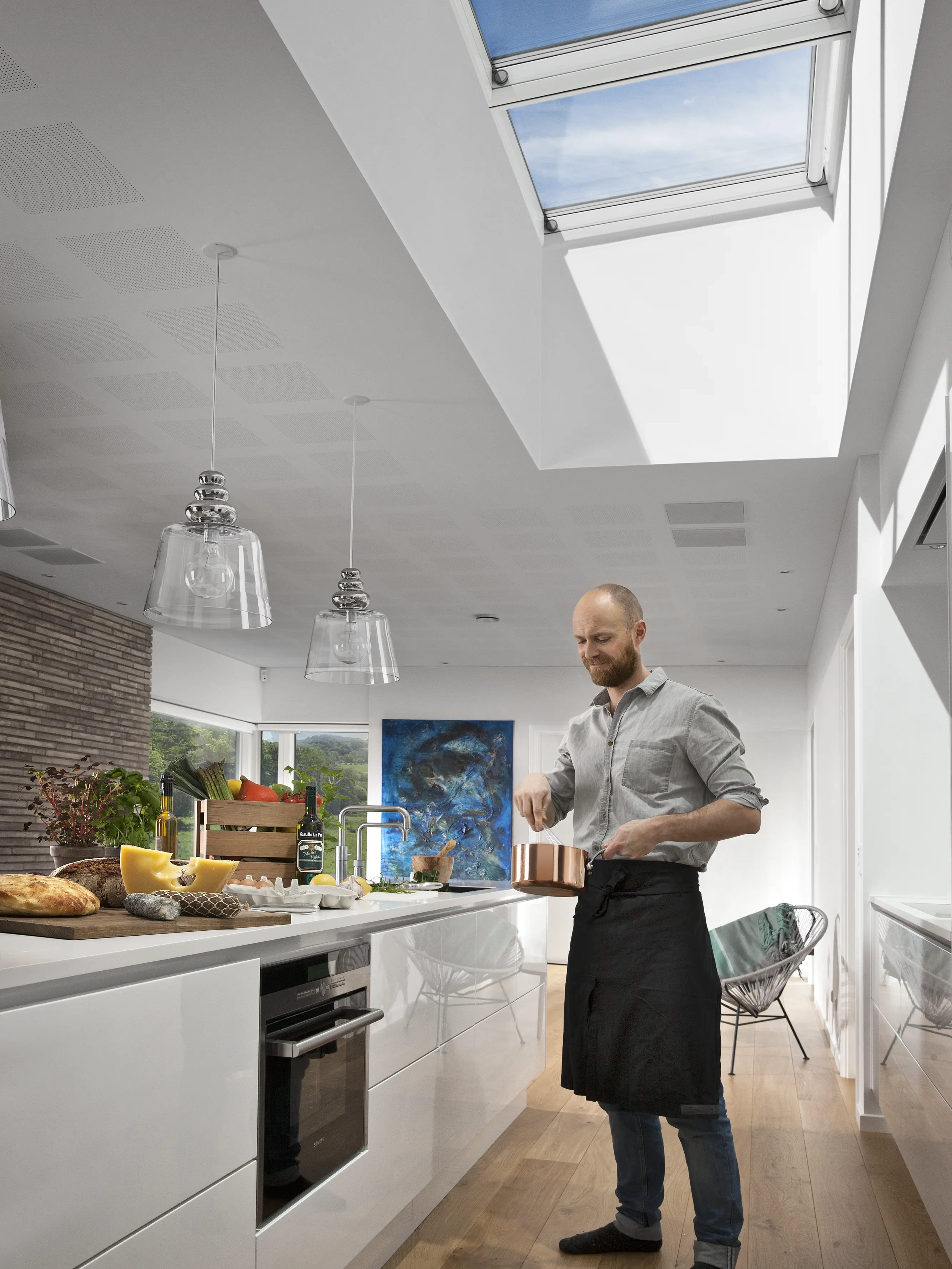 Cucina moderna con finestre per tetti VELUX sopra il piano di lavoro