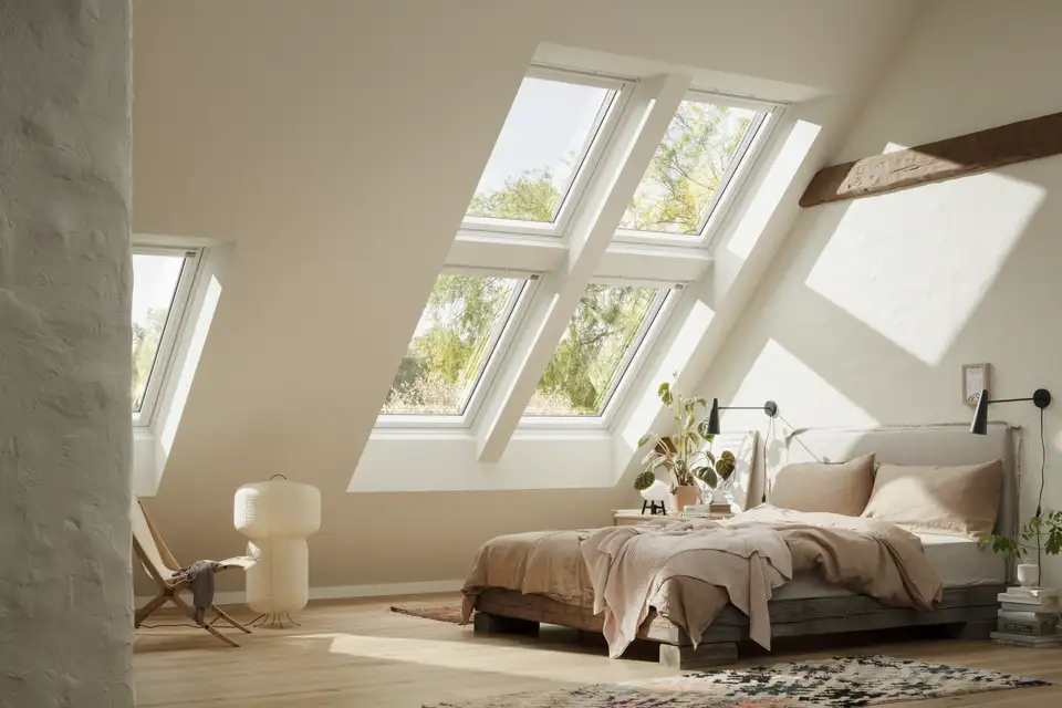 "Moderne slaapkamer met VELUX dakvenster, tweepersoonsbed, stijlvol interieur, witte en grijze tinten en natuurlijk licht." 