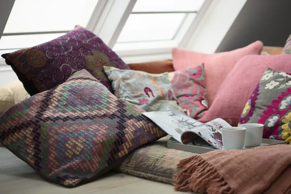 Coussins colorés et moelleux installés sous des fenêtres de toit VELUX 