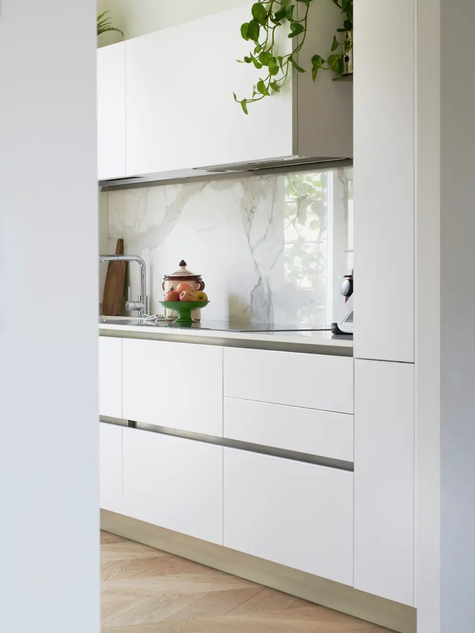 Contemporary kitchen with marble island, open window and wooden cabinetry