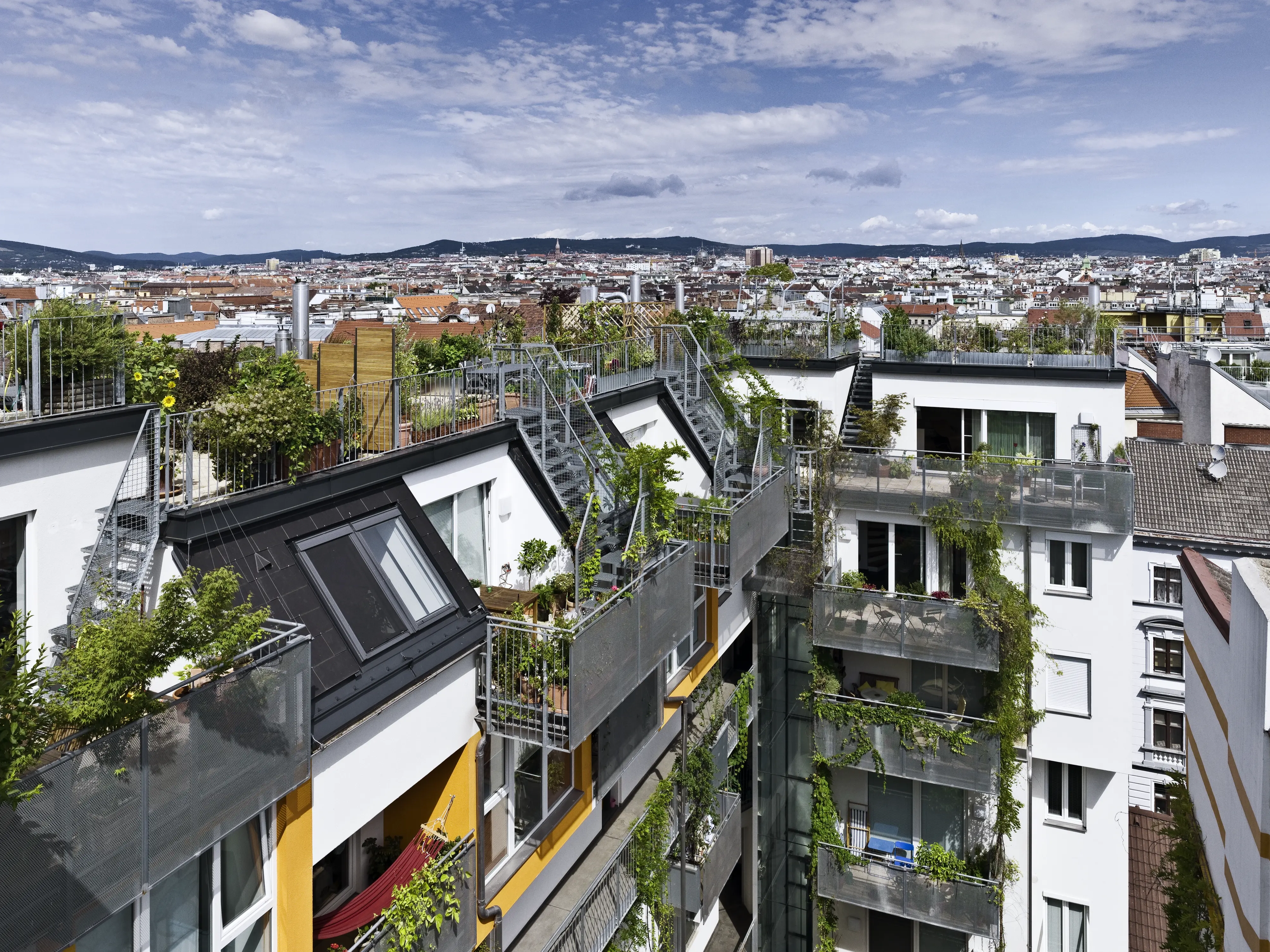 Bâtiment avec terrasse, balcons, fenêtres verticales et deux fenêtres de toit VELUX sur une pente de toit