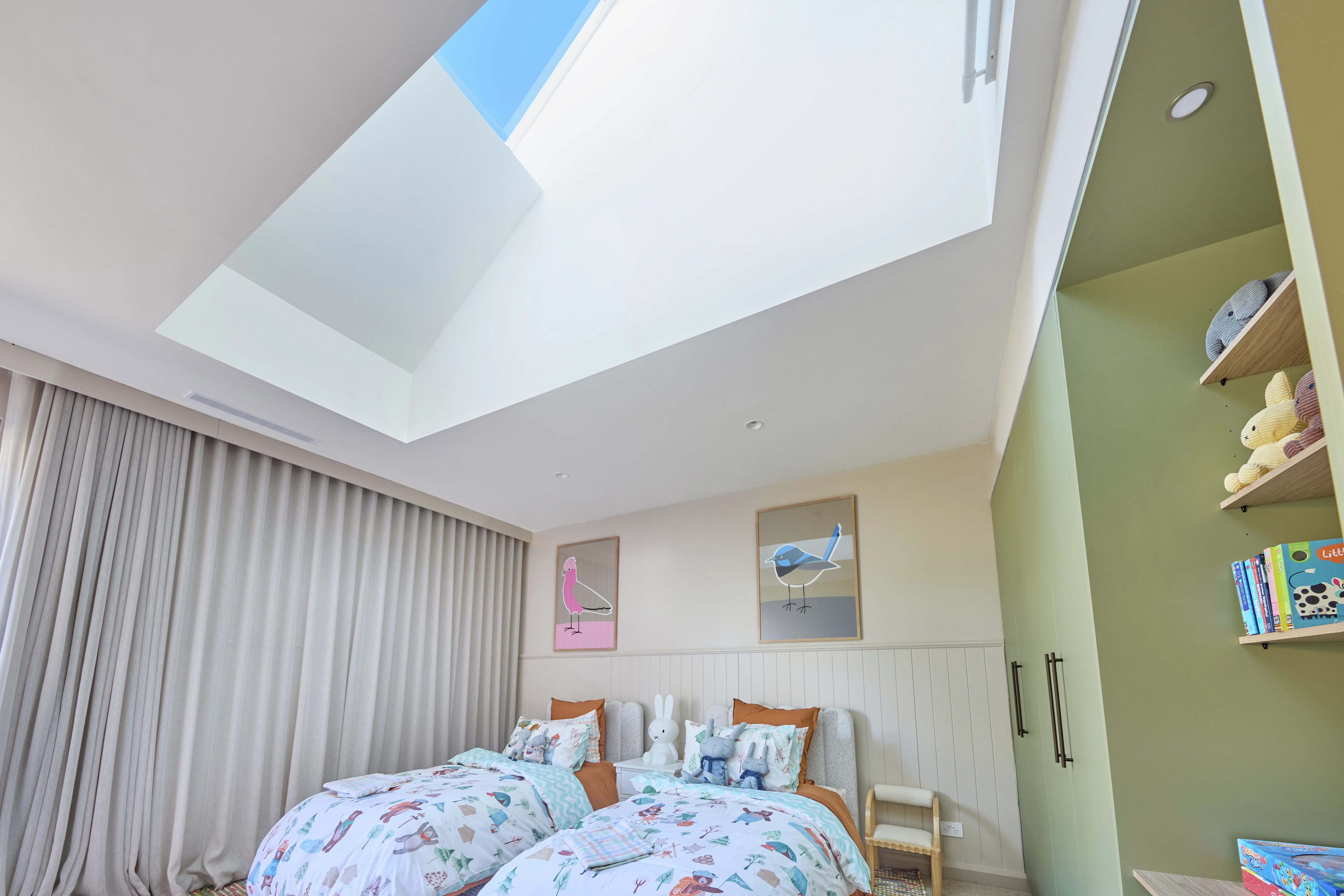 Kids room with twin beds and a large skylight window.