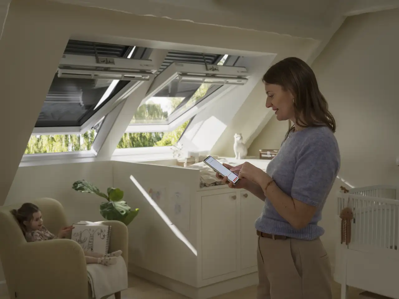 Woman using an app to control the roof windows in a child's bedroom. 