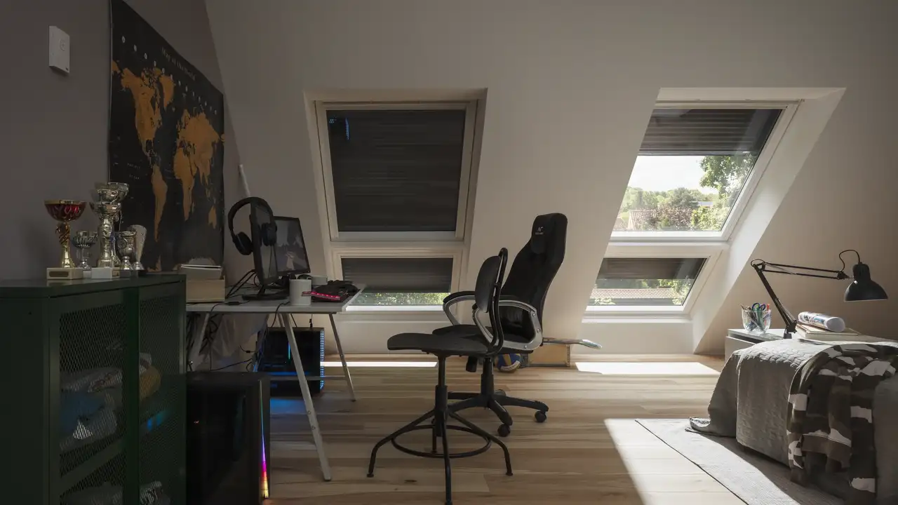 Chambre d’enfant avec deux fenêtres de toit VELUX côte à côte, équipées de volets roulants extérieurs.