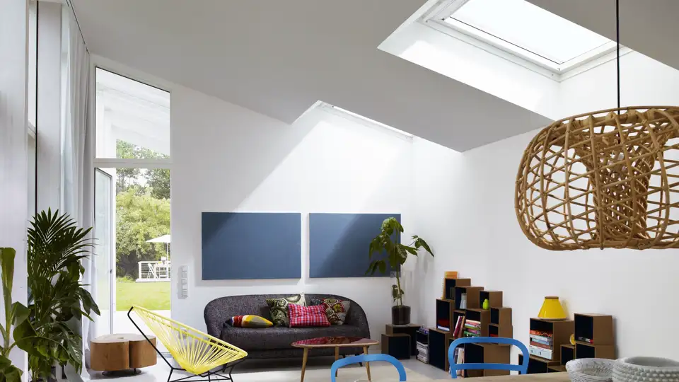 Salon au style rétro avec couleurs vives et mobilier des années 60, éclairé par des fenêtres de toit VELUX.