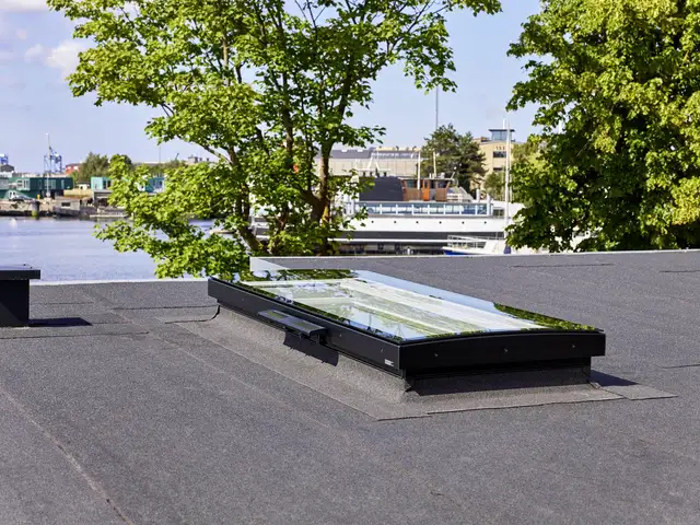 Fladt tag med tagpap og moderne ovenlysvindue i bymiljø