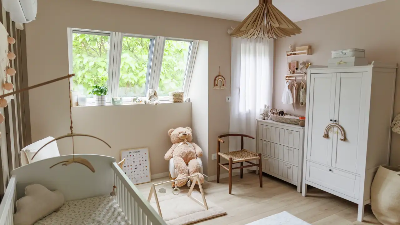 Nursery room with crib, teddy bear and large windows letting in natural light