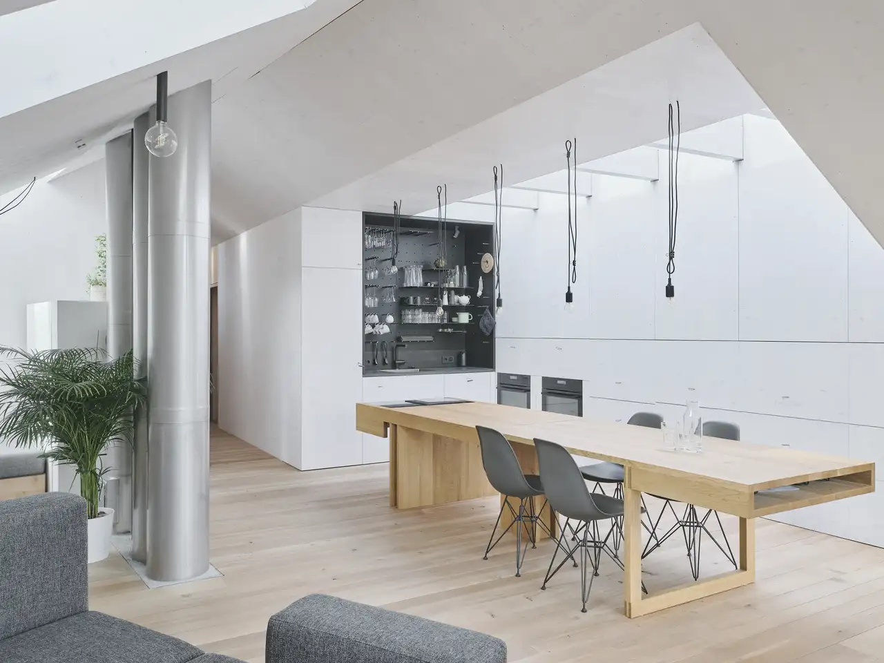 Heller Massivholztisch zum Ausziehen mit schwarzen Designstühlen und flächendeckendem Lichteinfall durch Dachfenster | VELUX Magazin