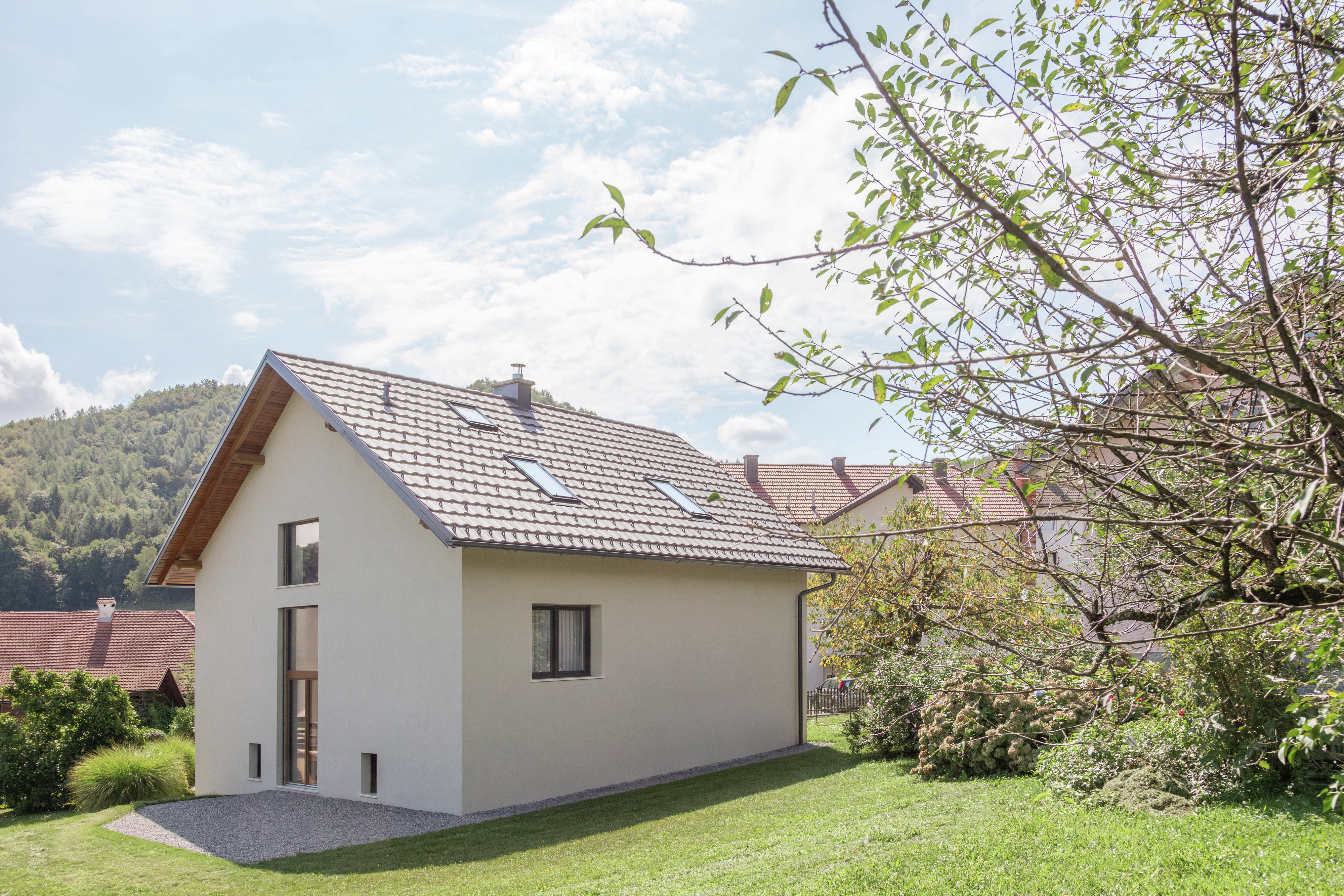 Moderný dom so strmou strechou a strešnými oknami VELUX v malebnej oblasti