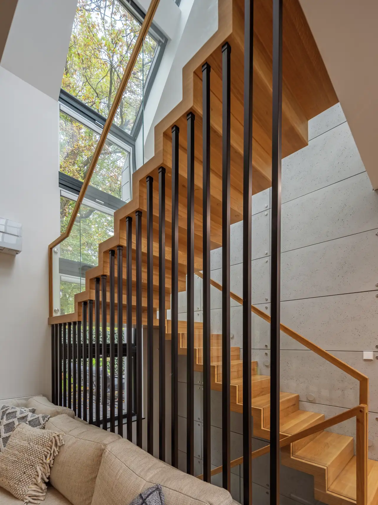 Moderna scala in legno che porta all'ultimo piano di fronte ad un'ampia soluzione finestrata | Rivista VELUX
