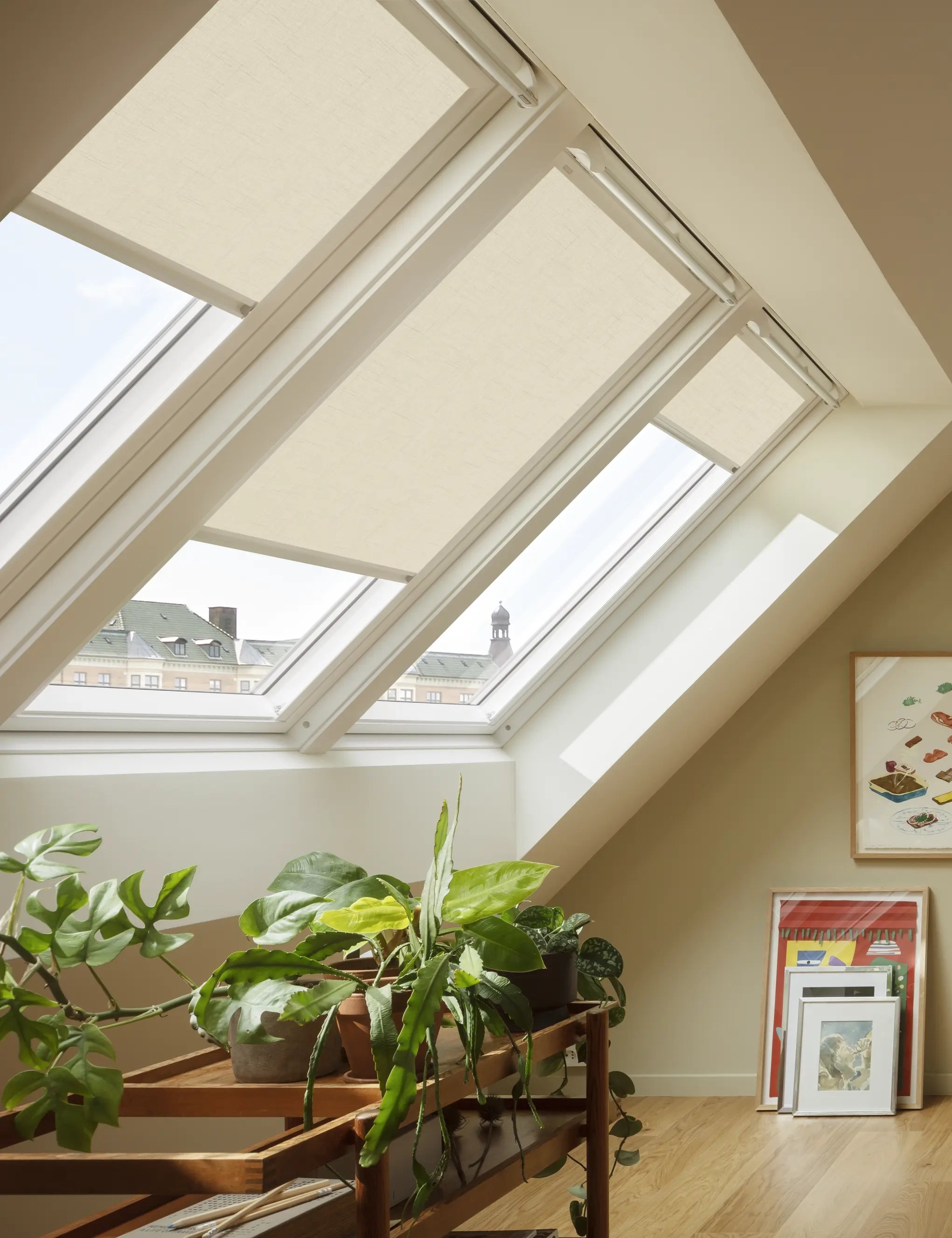 Attic workspace with sloped ceiling, VELUX roof windows, and vibrant decor.