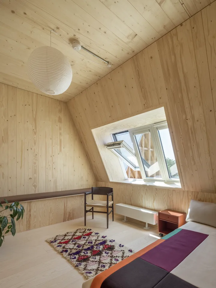 Innenansicht eines mit hellem Holz verkleideten Wohnraums mit drei Dachfenstern | VELUX Magazin