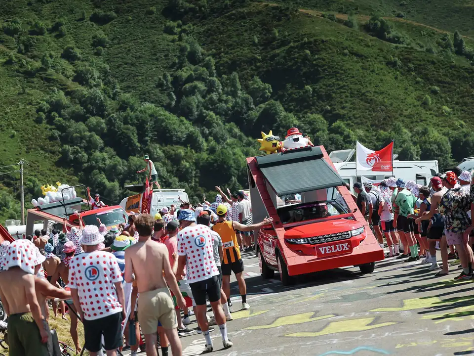 Vozilo z napisom VELUX v paradi z živahno množico med Tour de France 2025.