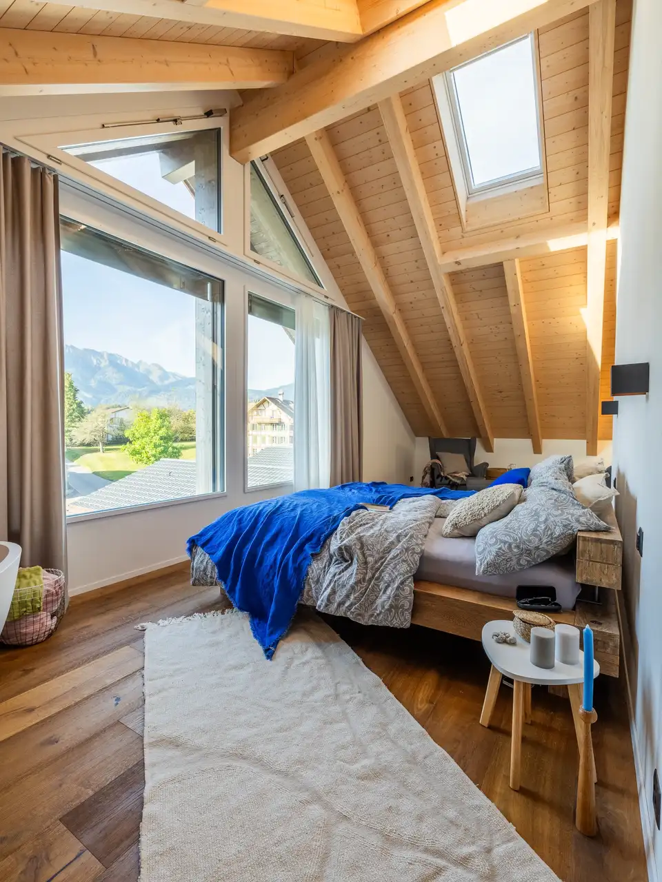 Camera da letto in mansarda con finestra verticale con vista sull’esterno e una finestra per tetti 
