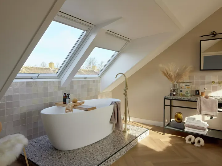 Modernes Badezimmer im Dachboden mit VELUX Dachflächenfenster und freistehender Badewanne.