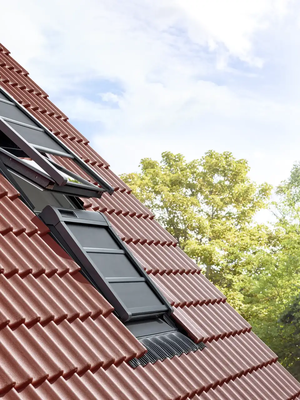 Hellend dak voorzien van VELUX dakvensters uitgerust met verduisterende buitenste zonneschermen