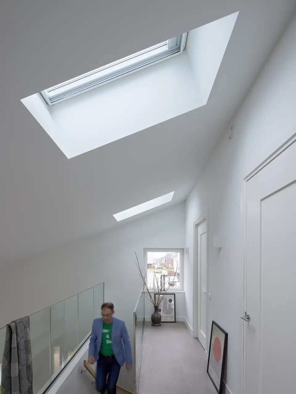 Overloop met schuine plafonds en VELUX dakramen, lichte en luchtige ruimte.