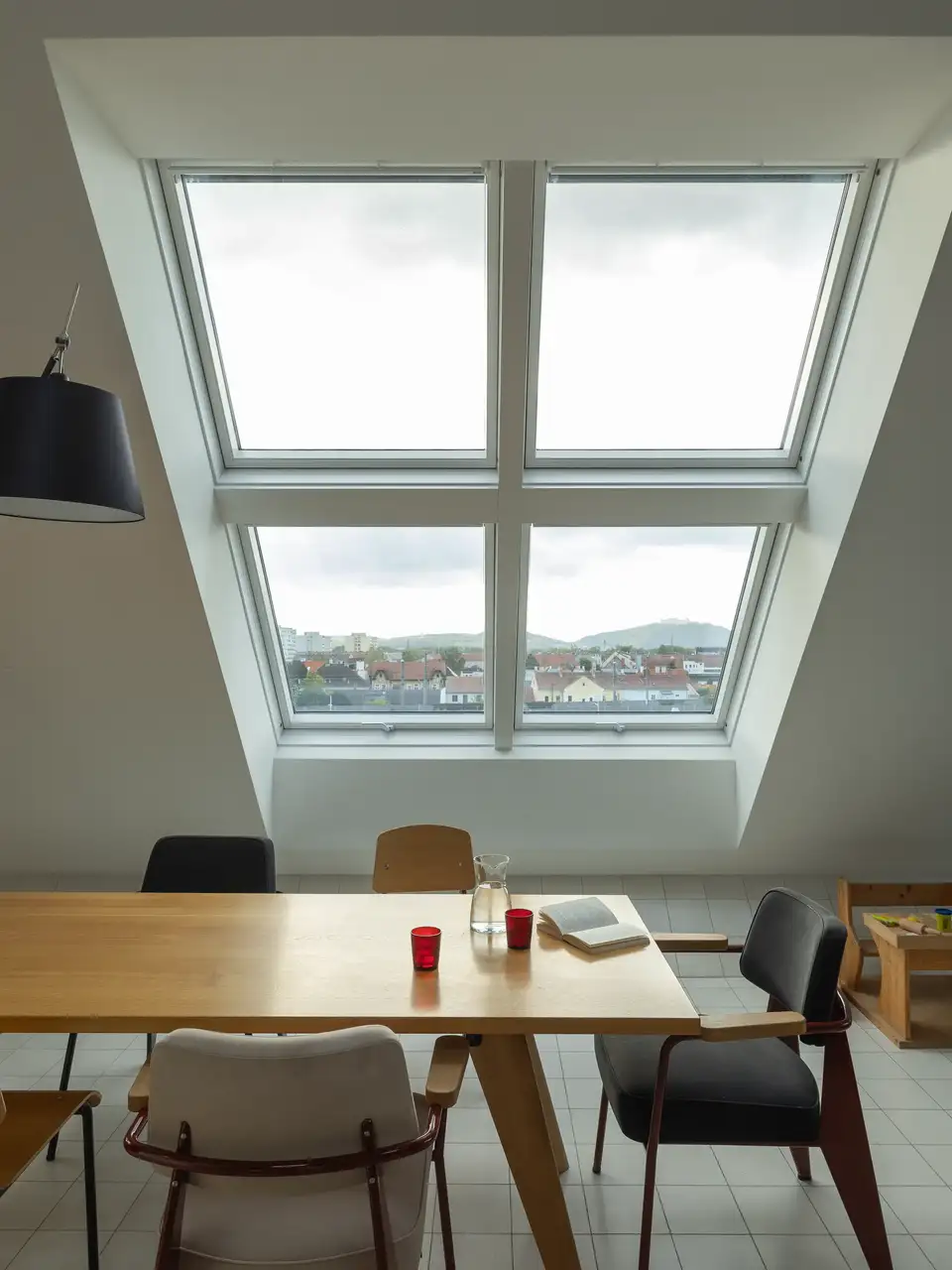 VELUX çatı pencerelerinin bulunduğu yemek odası.