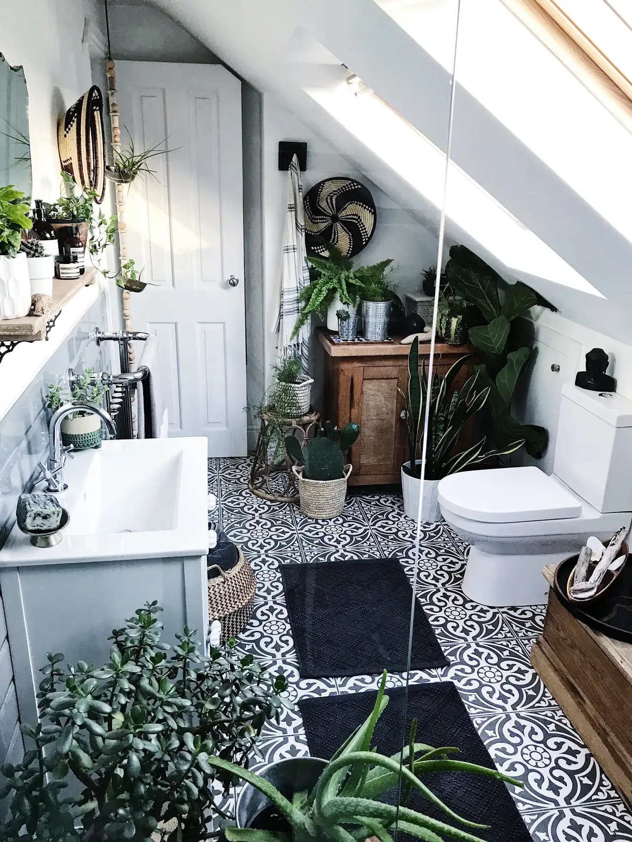 Bagno piccolo, in bianco e nero, con tante piante e mobili in legno | Rivista VELUX