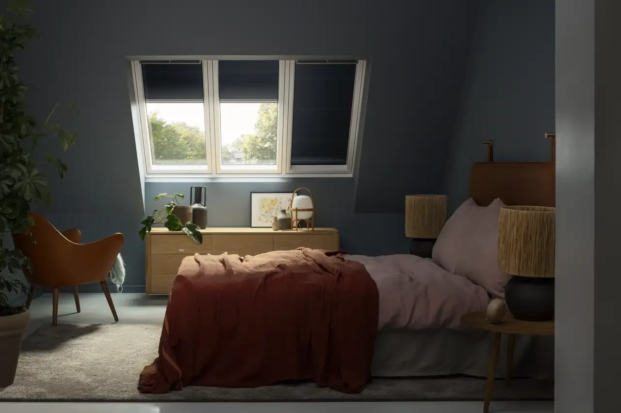 Abgedunkeltes Schlafzimmer mit Dachschräge und drei Dachfenstern | VELUX Magazin