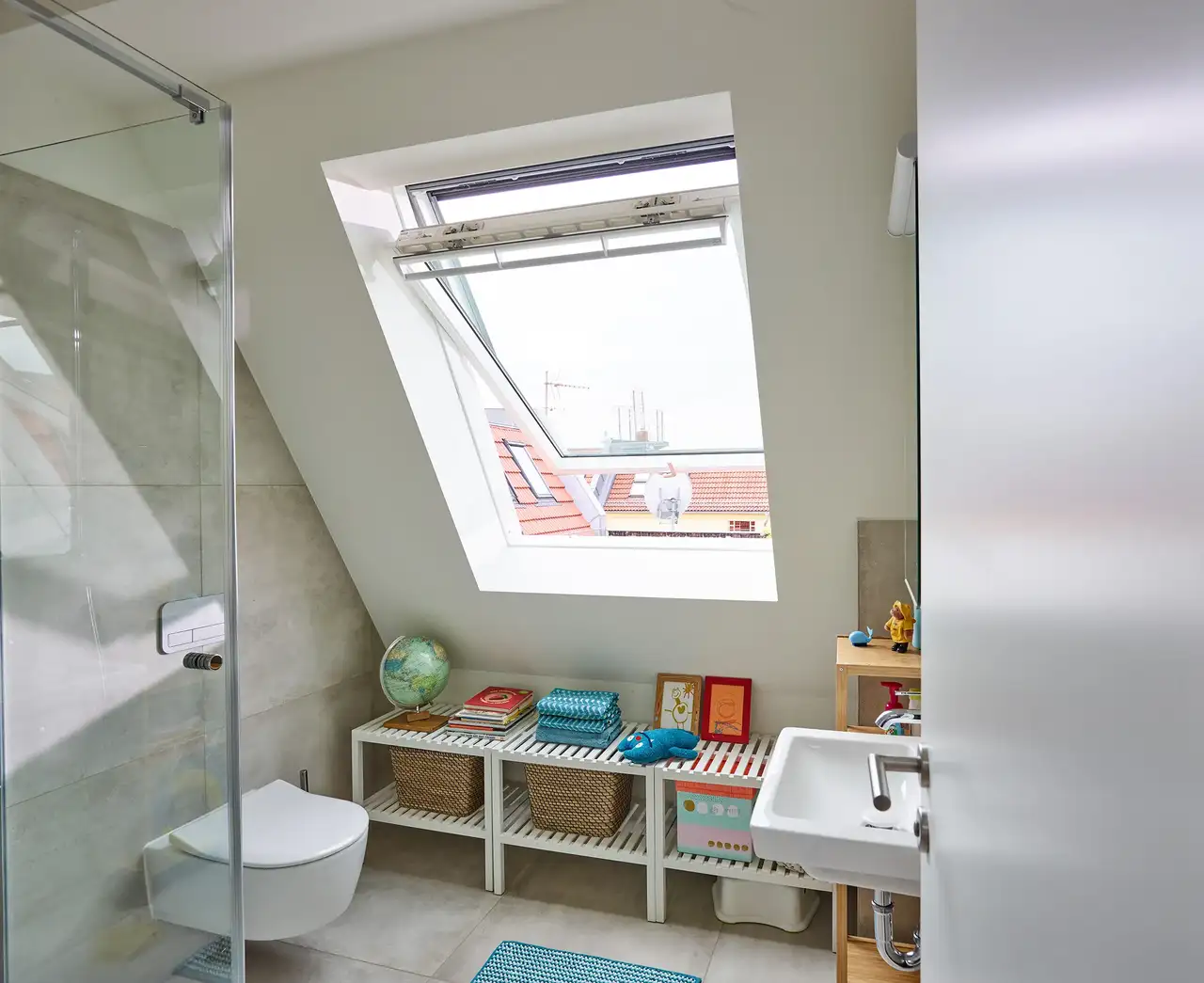 Bagno mansardato con finestra per tetti VELUX aperta. 