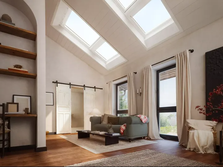 Gemütlicher Dachboden-Wohnraum mit natürlichem Licht von VELUX Dachflächenfenstern, hölzernen Akzenten und weicher Dekoration.