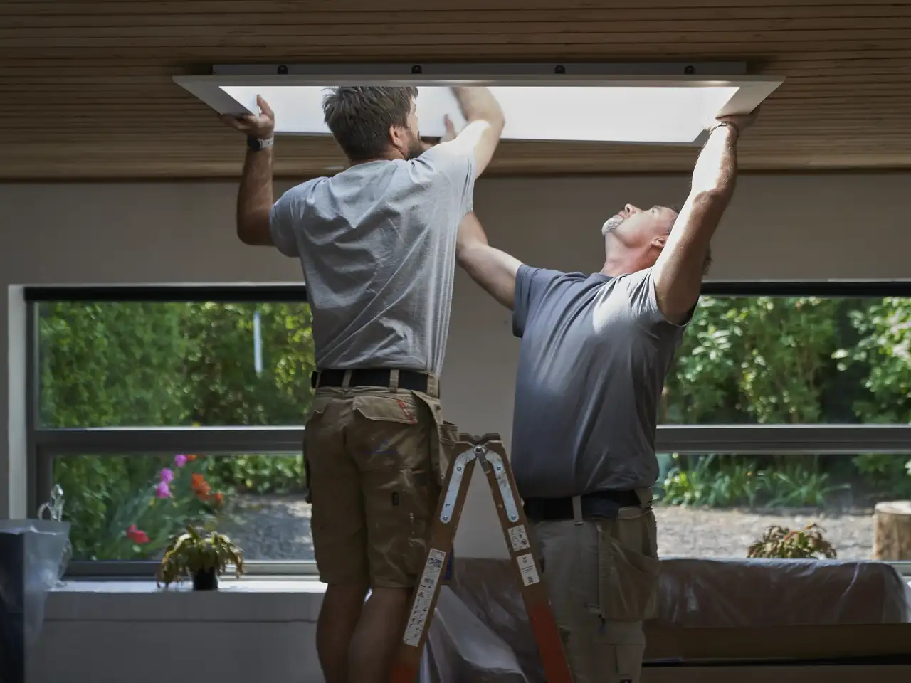 Due artigiani assemblano il telaio di una finestra per tetti piani | Rivista VELUX