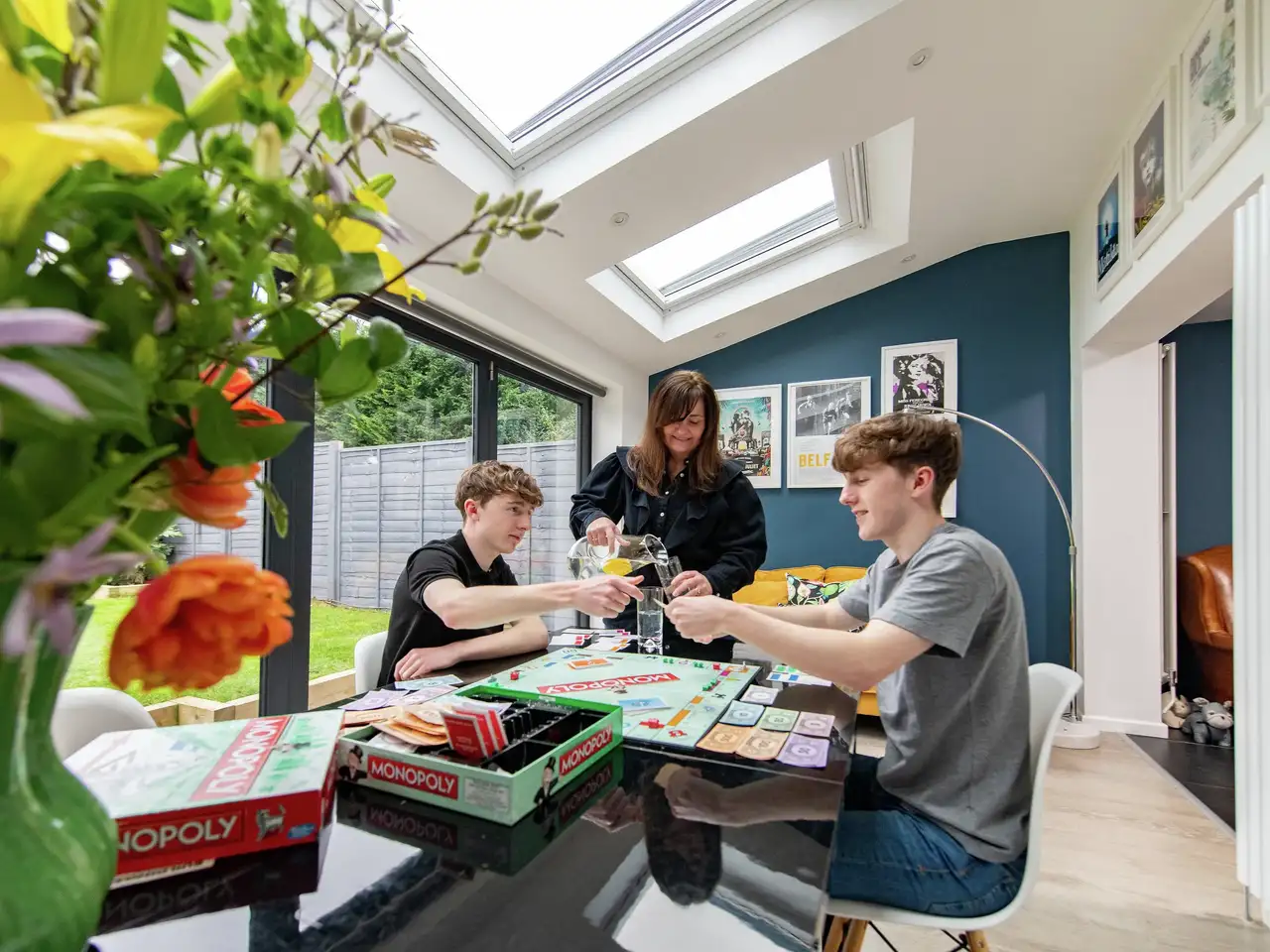 Family playing board games in a modern extension with roof windows.