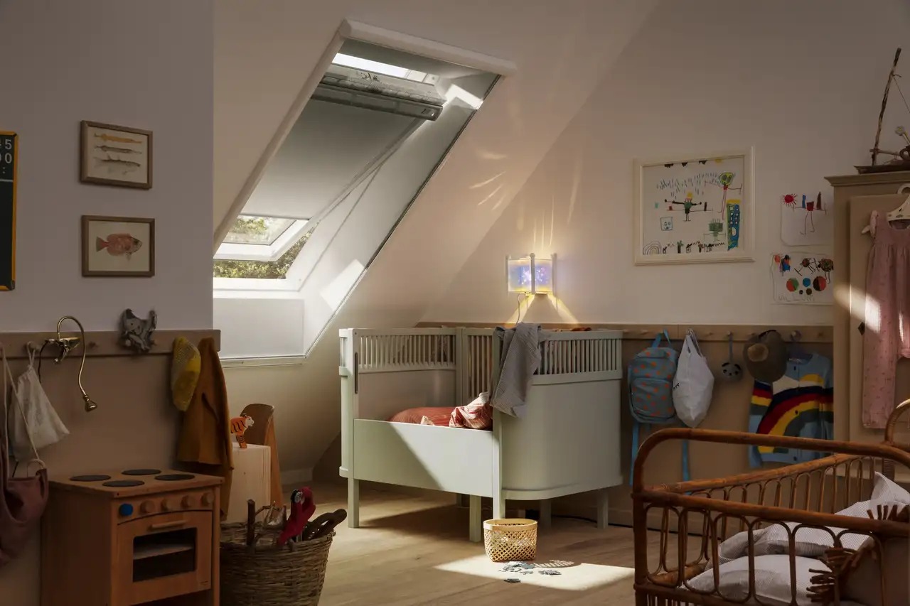 Chambre d’enfant équipée d’une fenêtre de toit VELUX protégée par une moustiquaire abaissée.