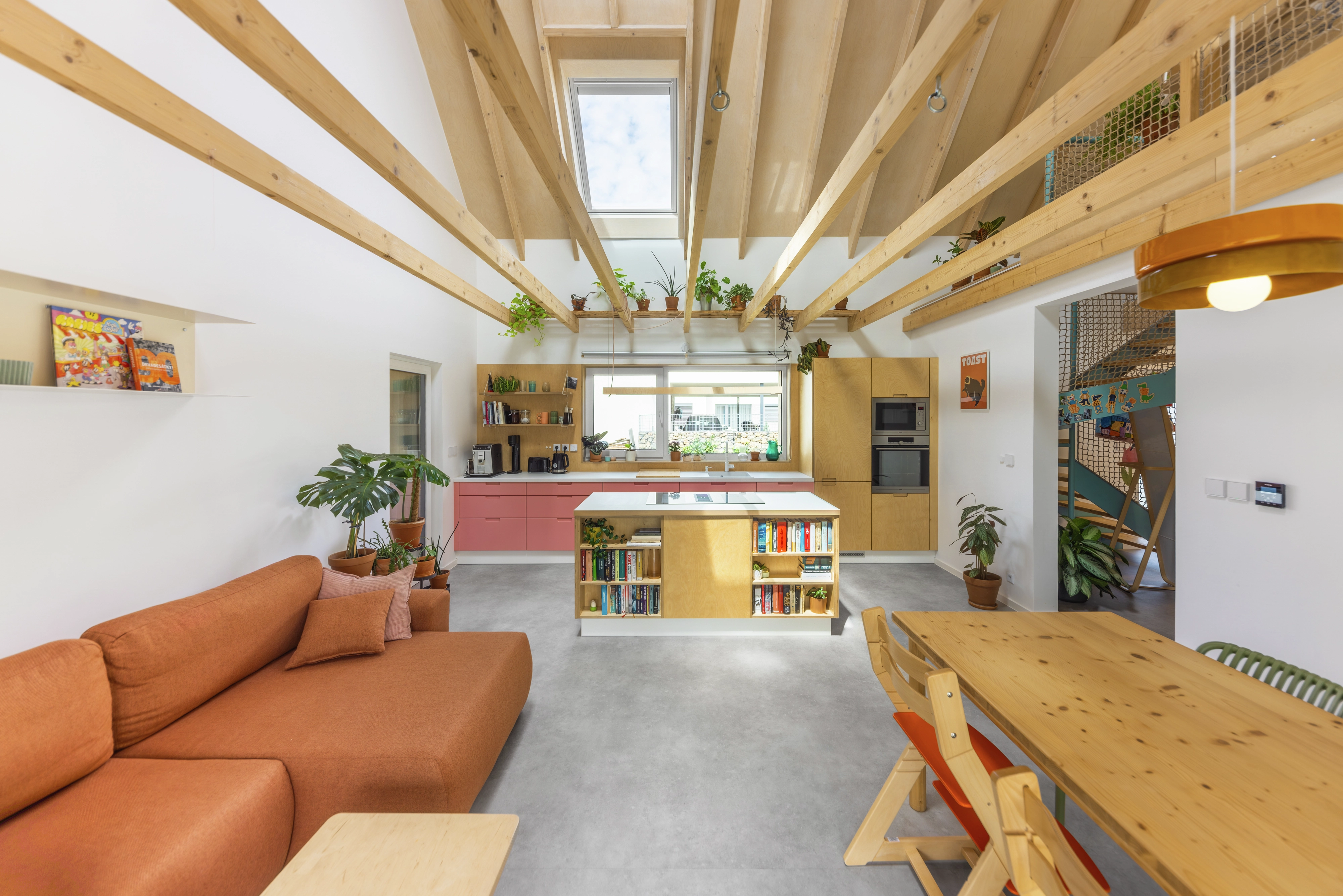 Modern kitchen with skylight, visible rafters, and vibrant decor.