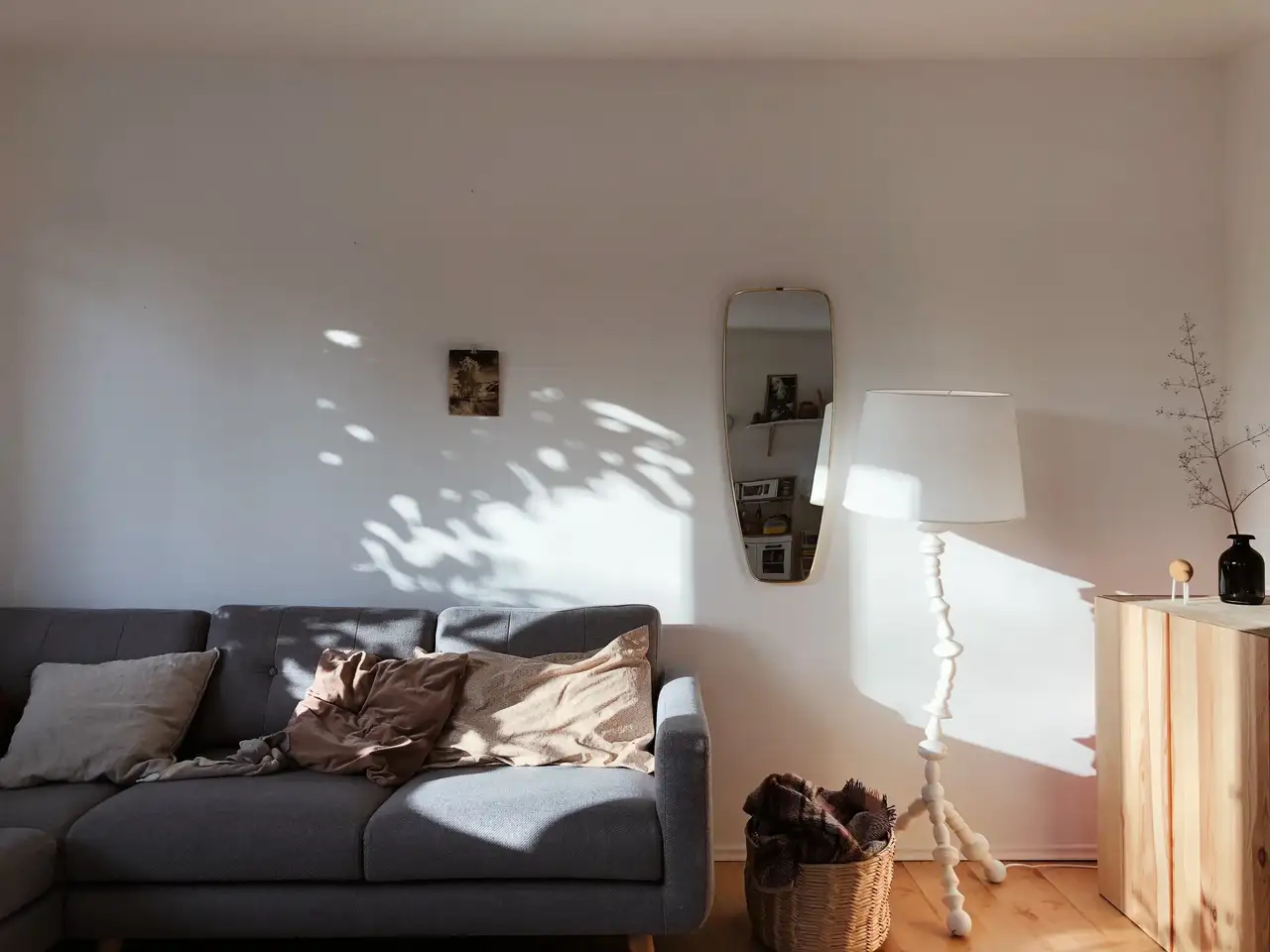 Camera dei giovani illuminata dalla luce del giorno con divano grigio e cesto della biancheria pieno | Rivista VELUX