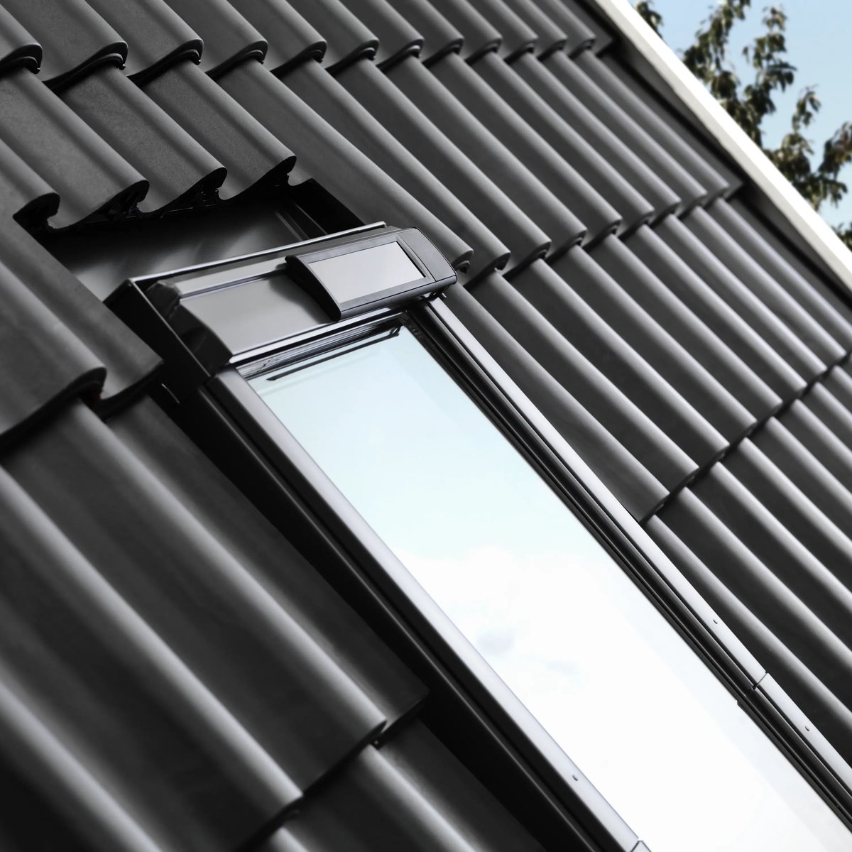 Black tile roof with VELUX window, modern design and natural light.