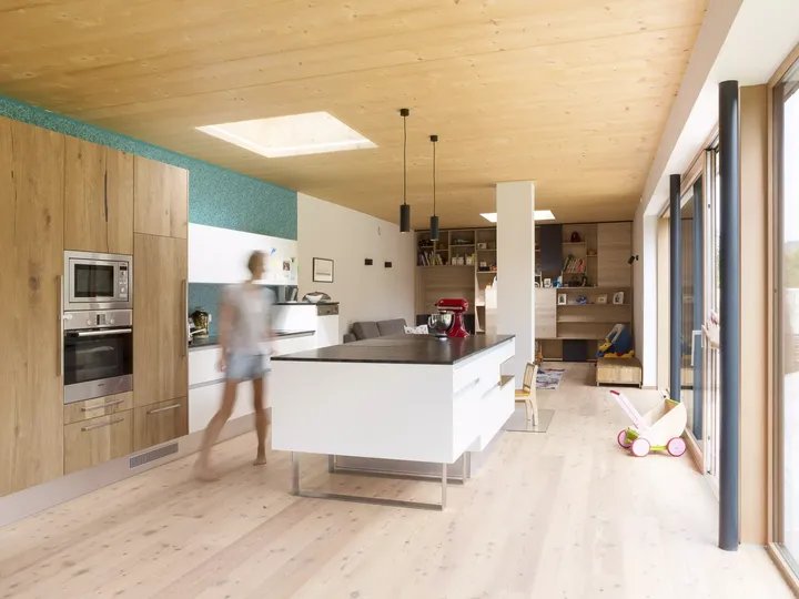 Helle moderne Küche mit VELUX Dachflächenfenster, hölzernen Schränken und zentraler Insel.