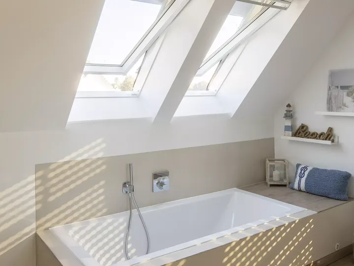 Modernes Badezimmer im Dachboden mit VELUX Dachflächenfenstern und freistehender Badewanne.