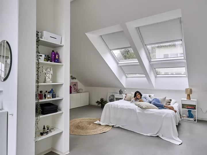 Minimalistisches Schlafzimmer im Dachboden mit natürlichem Licht von VELUX Dachflächenfenstern und moderner Dekoration.