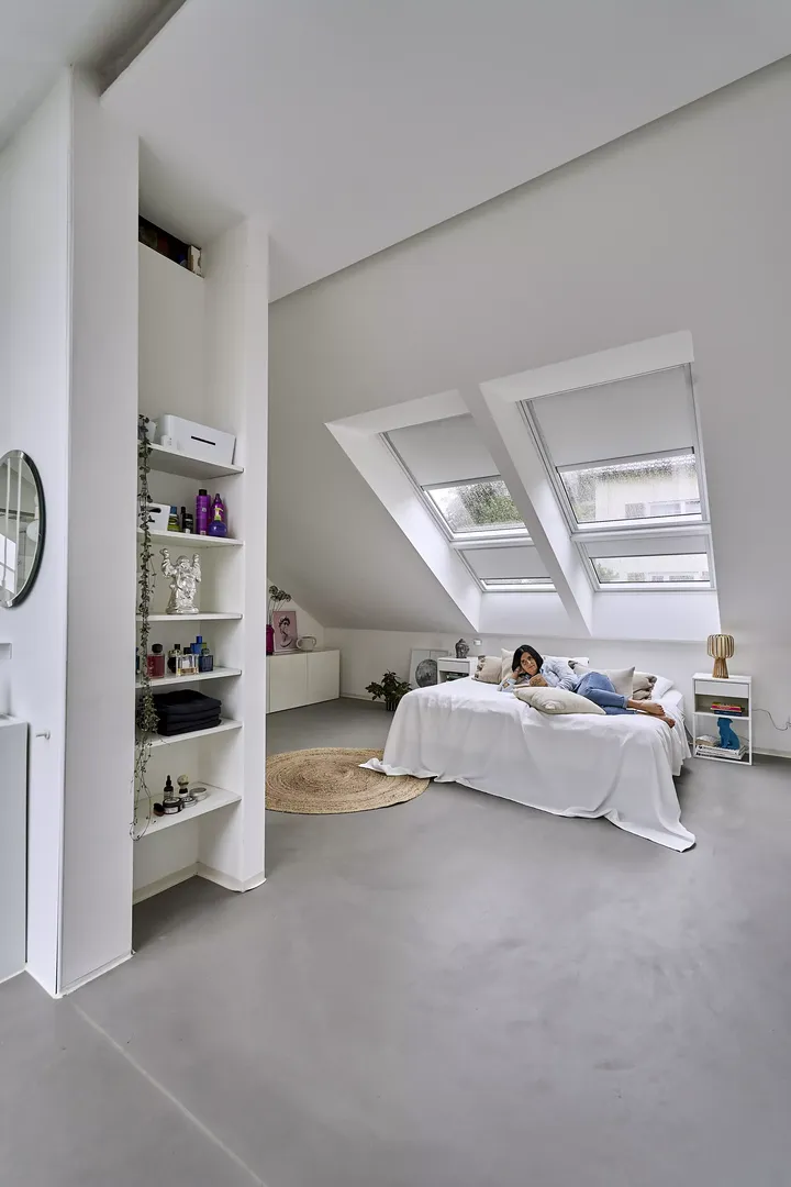 Modernes Schlafzimmer mit natürlichem Licht von VELUX Dachflächenfenstern und minimalistischer Dekoration.
