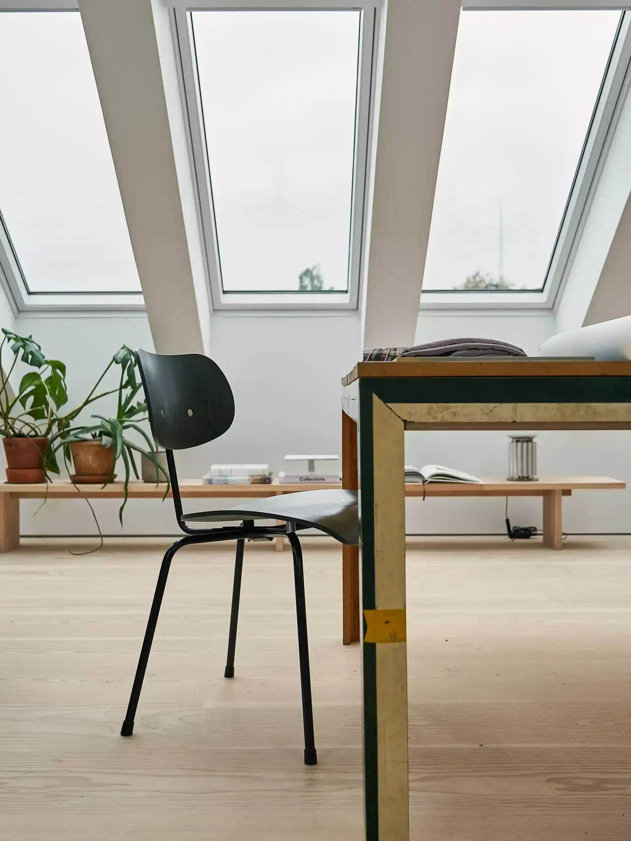 Modernes Home-Office mit natürlichem Licht durch VELUX Dachflächenfenster und minimalistischen Möbeln.