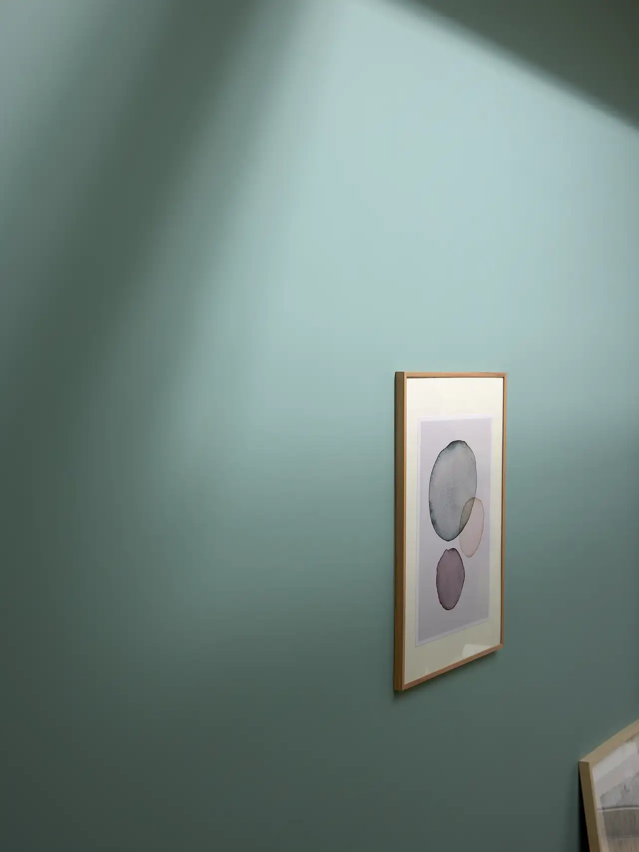 La parete turchese con quadro astratto al centro è illuminata dalla luce del giorno | Rivista VELUX