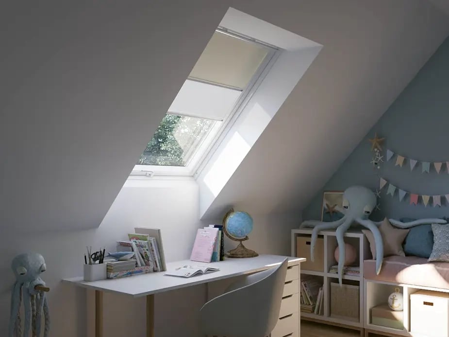 Attic kids room with sloped ceiling and VELUX roof window, playful decor.
